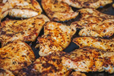 Sıcak kavrulmuş ızgara baharatlı tavuk kızartma yüzeyinde döşeme closeup görünümü. Yatay renkli fotoğraf.