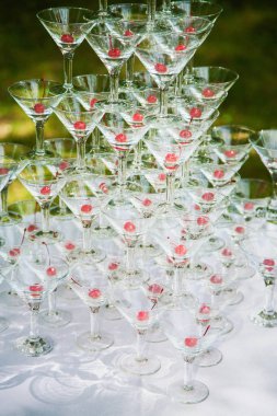 Piramit içlerinde kırmızı kiraz ile birçok boş bardak. Açık havada tatil ya da düğün kutlama parti. Ikram Servisi. Dikey renkli fotoğraf.