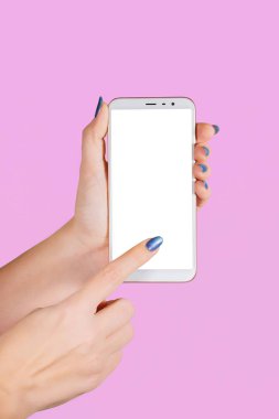 Beyaz modern smartphone üzerinde mor arka plan izole boş beyaz ekran ile tutan iki eller closeup görünümü. Tırnaklara sahip modern parlak mavi manikür. Dikey renkli fotoğraf.