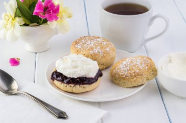 Ahududu reçeli, kaymak ve çay lezzetli İngilizce çörekler, yakın çekim.