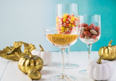 Dekorasyon fikir. Şükran tatil dekorasyon şarap, Gözlük, beyaz ve altın pumpkins, Altın yaprağı şekerler ile masa.