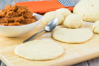 Rulo hamur ve bir kesme tahtası üzerinde kase kabak doldurma yakın çekim.