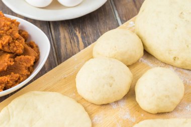 Rulo hamur ve bir kesme tahtası üzerinde kase kabak doldurma yakın çekim.