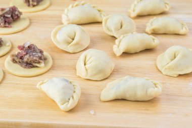 Sığır eti köfte el yapımı farklı şekiller kesme tahtası üzerinde Kapat