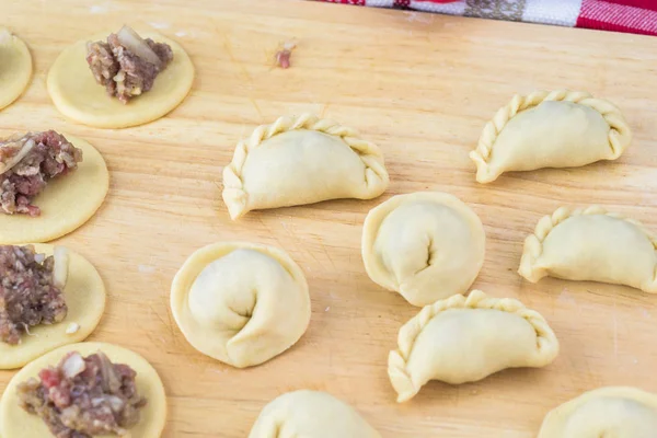 Sığır eti köfte el yapımı farklı şekiller kesme tahtası üzerinde Kapat