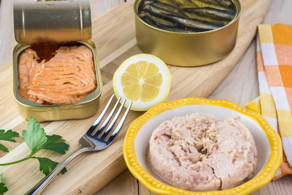 Open  canned fish. Tin can with smoked salmon fillets, tuna, sprats.