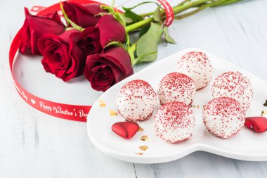 Mini kek ve kırmızı gül - beyaz plaka Sevgililer günü için hediye kapatın. Tebrik kartı kavramı.