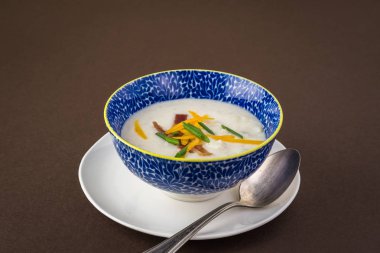 Pastırma ile yüklenen karnabahar çorbası ile kase kaşar peyniri. Frenk soğanı.