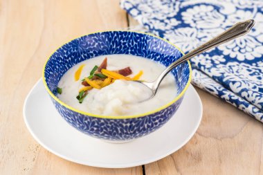 Pastırma ile yüklenen karnabahar çorbası ile kase kaşar peyniri. Frenk soğanı.