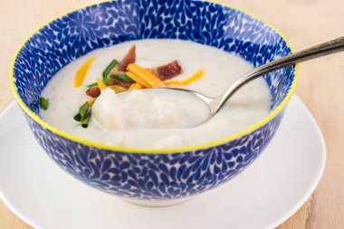 Pastırma ile yüklenen karnabahar çorbası ile kase kaşar peyniri. Frenk soğanı.