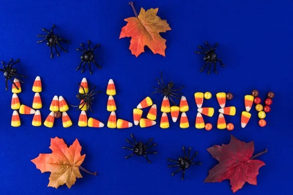Halloween background with candy letters, spiders and autumn leaves. — ストック写真