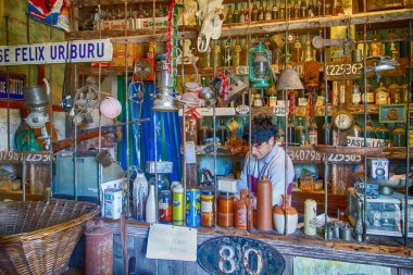 Tezgahın arkasında bir dükkan sahibi olan eski bir mağazanın dağınık içi.