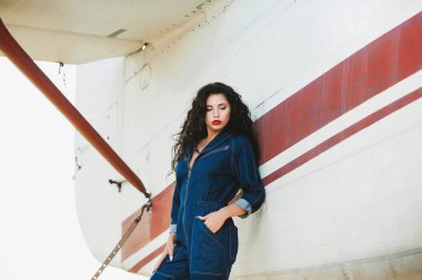 seksi kız kıvırcık saçlı ve denim tulum uçak yakınındaki
