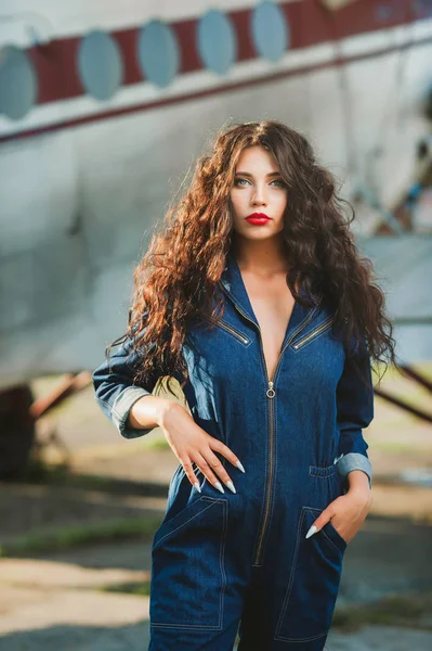 seksi kız kıvırcık saçlı ve denim tulum uçak yakınındaki