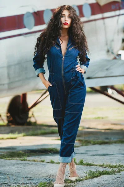 seksi kız kıvırcık saçlı ve denim tulum uçak yakınındaki