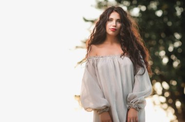 gevşek elbiseleri günbatımı arka plan üzerinde niteliğine güzel kıvırcık kız