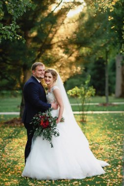 parkta düğün çift; gelin ve damat; iki kişinin sevgisi; gelin güzel bir buket tutar; düğün fotoğrafçılığı