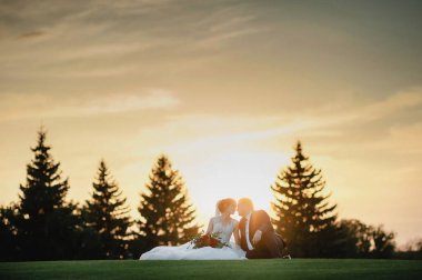 parkta düğün çift; gelin ve damat; iki kişinin sevgisi; gelin güzel bir buket tutar; düğün fotoğrafçılığı; Gelinlik