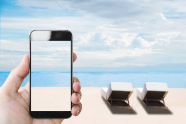 Yaz tatili, hareket eden smartphone sahilde yaz aylarında tutan el