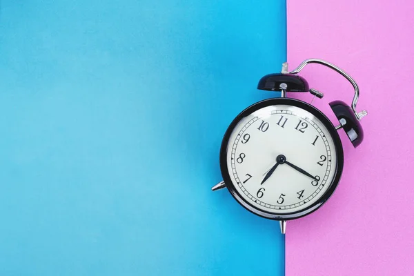 ピンクとブルーの背景にビンテージの目覚まし時計 — ストック写真