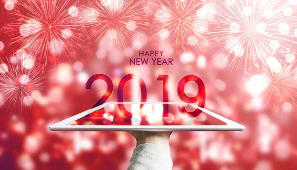 Новым 2019 Годом Рука Держит Цифровой Планшет Красным Фоном Bokeh — стоковое фото