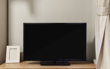Oturma odasında yerleşik rafta boş siyah perde ile TV açtı