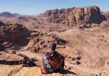 Wadi Rum çöl Ürdün'de dağ uçurumun kenarında oturan gezgin. Yaşam tarzı ve macera ve yolculuk seyahat