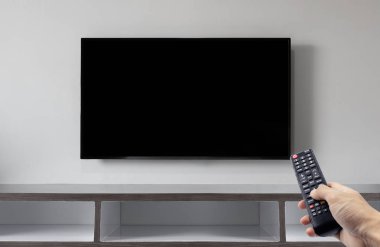 Televizyon uzaktan kumanda kullanarak el ile beyaz duvar