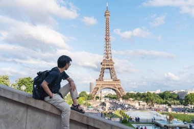 Eyfel kulesi, ünlü dönüm noktası ve Paris, Fransa seyahat hedef bakarak sırt çantası ile bir adam. Yaz aylarında Avrupa'da seyahat