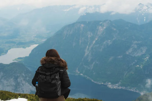 夏のオーストリアの山とハルシュタットの街の美しい空中写真を見てバックパックを持つ女の子 — ストック写真