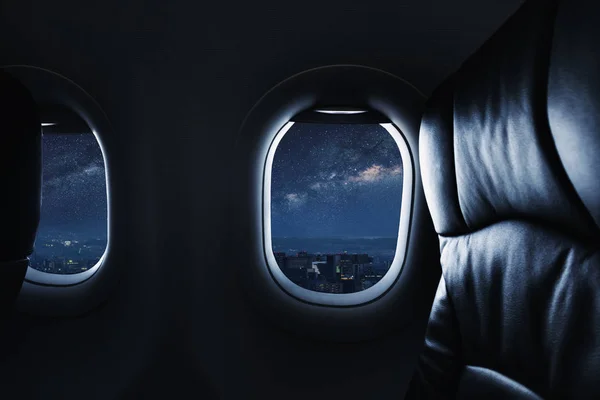 Looking through airplane window at night with sky full of stars and milky way