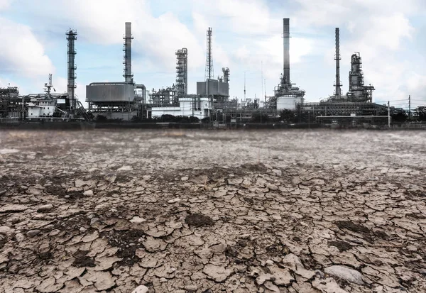 Old factory over dry cracked ground. Pollution and environmental problems