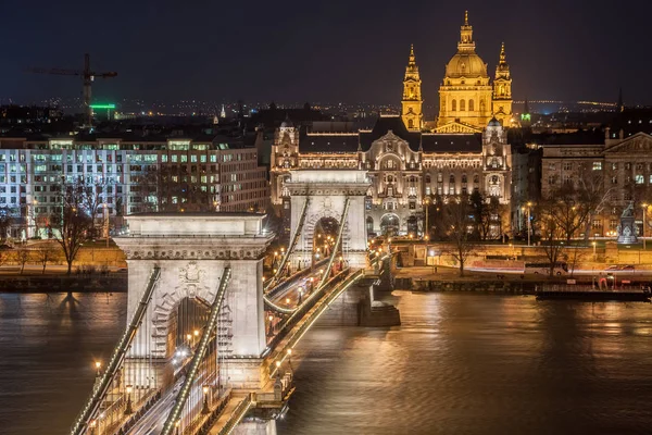 Vista nocturna del puente de la cadena Szechenyi y la iglesia de San Esteban en Budapest — Foto de Stock