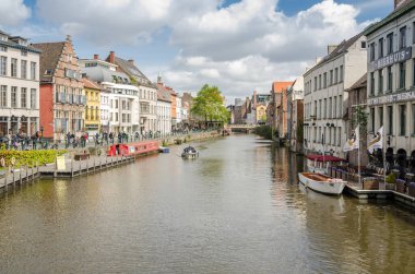 GHENT, BELGIUM - 16 Nisan 2017: Kanal boyunca renkli geleneksel evler ve Belçika 'nın popüler turistik kenti Gent' teki tekneler