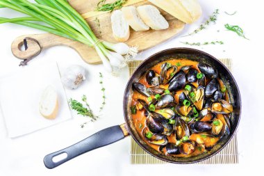  Lezzetli deniz ürünleri midye üzerine kırmızı sos dökülmüş bir tavada yeşil soğan ile