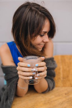 Bir bardak kakaolu genç bir kız kafedeki terasta oturuyor.