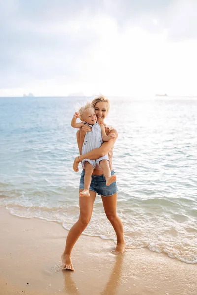 Šťastná maminka na dovolené objetí její malý smích syn — Stock fotografie