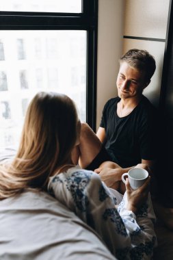 Bir adam ve bir kız yüzlerinde maskelerle yerde oturuyorlar.