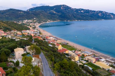 Alacakaranlıktaki Agios Georgios Pagon plajının hava aracı görüntüsü. Yunanistan 'ın Korfu adasında güzel bir kıyı köyü ve körfez. İyon Denizi 'nde mükemmel bir yaz seyahati..