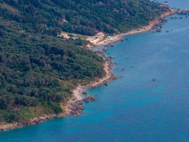 Yunanistan 'ın Korfu kentinin engebeli, ormanlı kıyı şeridindeki görkemli lüks bir villanın insansız hava aracı görüntüsü. İyon Denizi 'nin güzel turkuaz sularına bakan tenha bir özel mülk..