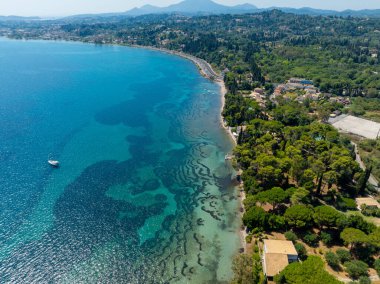 Yunanistan 'daki Korfu kıyı şeridinin çarpıcı hava manzarası. İyon Denizi 'nin kristal berrak turkuaz suları yemyeşil kıyıların yanındaki deniz tabanının benzersiz desenlerini ortaya koyuyor.
