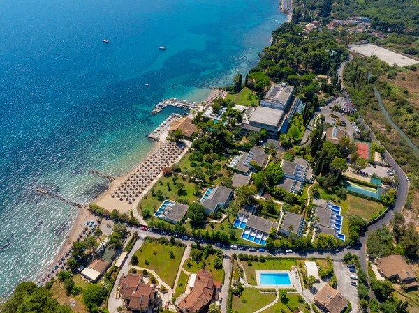 Beautiful aerial drone landscape of a coastal resort on the Greek island of Corfu. Showcasing the hotel, private pools, beach, and the stunning blue waters of the Ionian Sea
