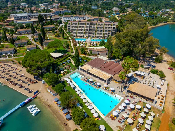 Aerial view of a sprawling luxury beach resort in Corfu, Greece. Featuring large swimming pools, restaurants, and a private beach for a perfect family summer holiday destination