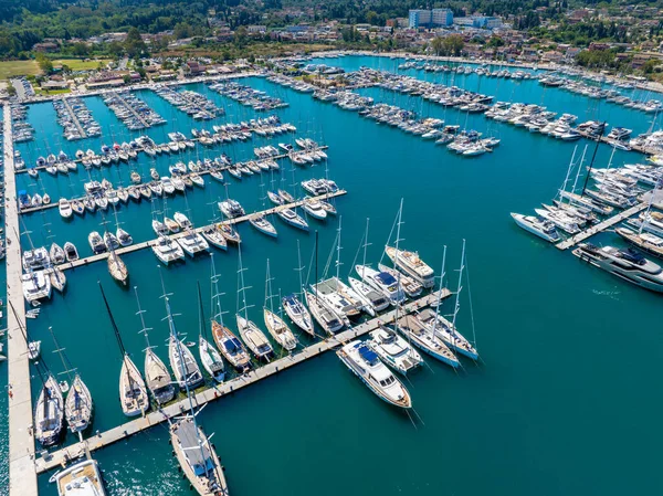 Aerial drone view of sailboats and luxury yachts moored at the docks of Gouvia Marina, Corfu. A busy nautical destination in Greece during the summer holiday season