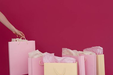birkaç kağıt poşetler pembe arka plan, kadın el üzerinde görüntü