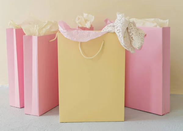 黄色の背景にピンクと黄色の紙のショッピング バッグ — ストック写真