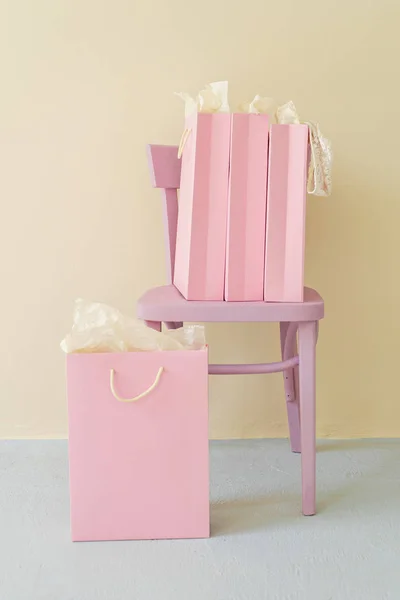 group of pink shopping bags on pink chair