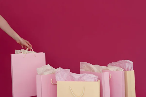 いくつかの紙のショッピング バッグ女性手 ピンクの背景のイメージ — ストック写真