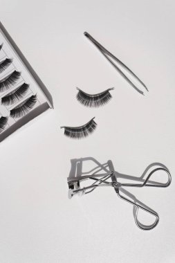 Siyah yanlış beyaz şeritler kümesiyle kıvırıcı ve cımbız lashes 