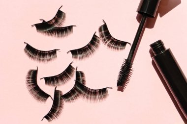 Black false lashes strips with mascara on pink background  clipart